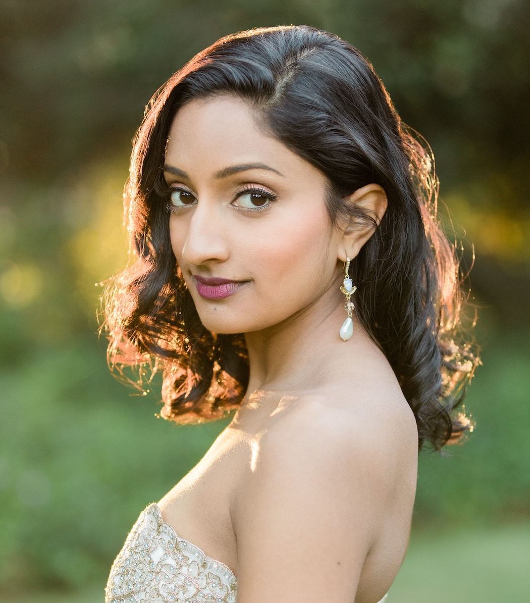 Soprano Maya Kherani in a beaded strapless gown, looking over her shoulder in warm evening light